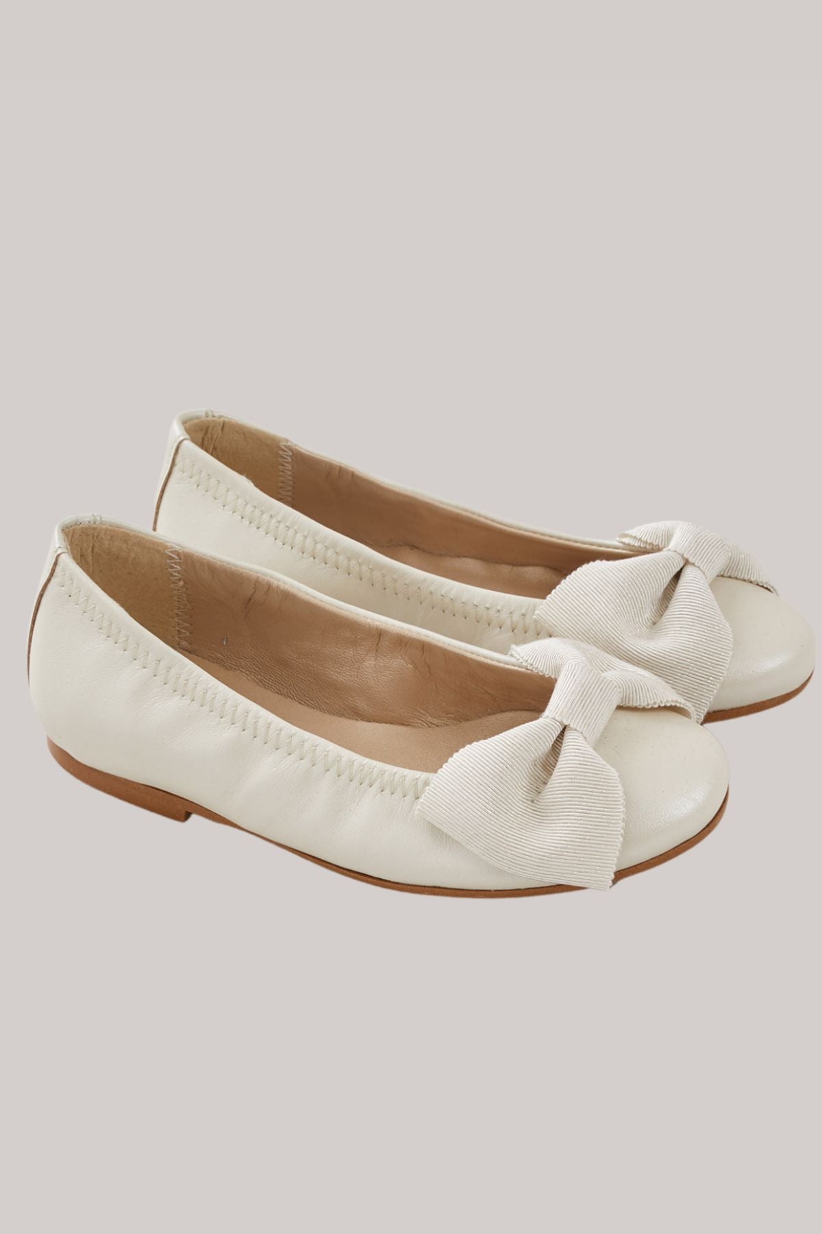 Ballerina Bow -  Ivory - Strawberries & Cream - Ingrid Lewis - Designer 
Pair of white flat shoes with bow details.
