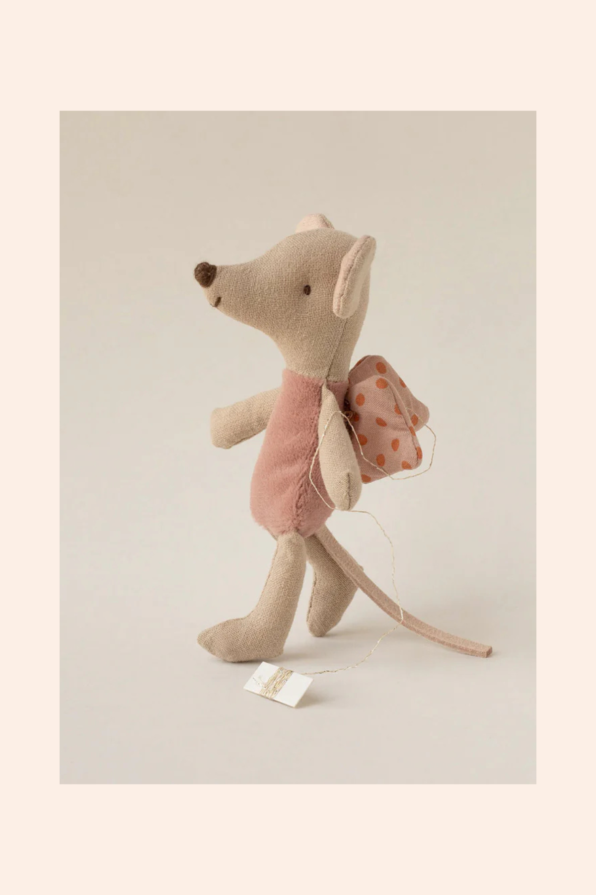 Stuffed mouse toy with a pink dress and backpack on a light gray background