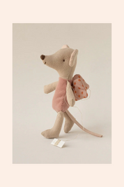 Stuffed mouse toy with a pink dress and backpack on a light gray background