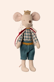 Stuffed toy mouse dressed as a king with a crown, sweater, and shorts on a beige background