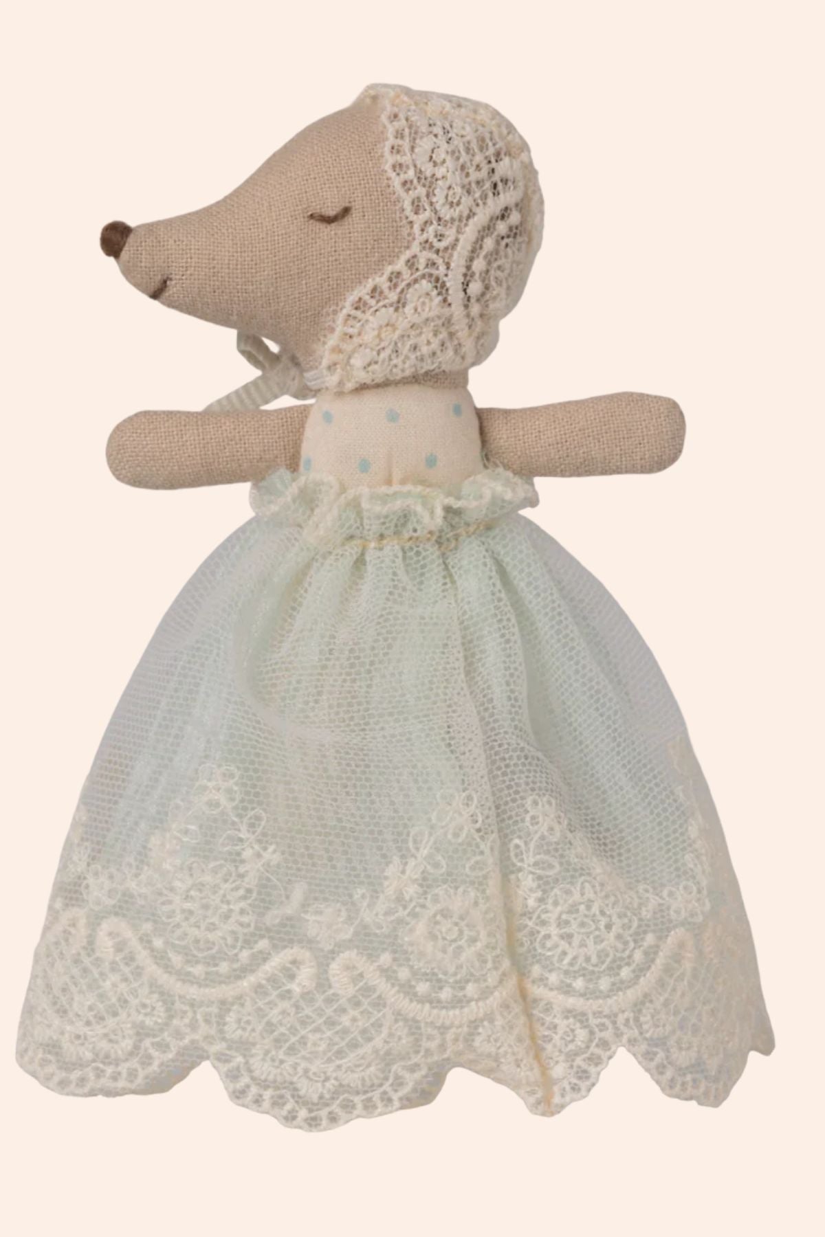 Stuffed animal toy wearing a lace dress and bonnet on a white background