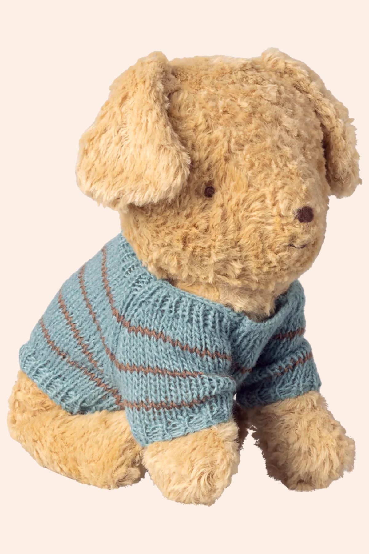 Teddy bear wearing a blue striped sweater on a beige background