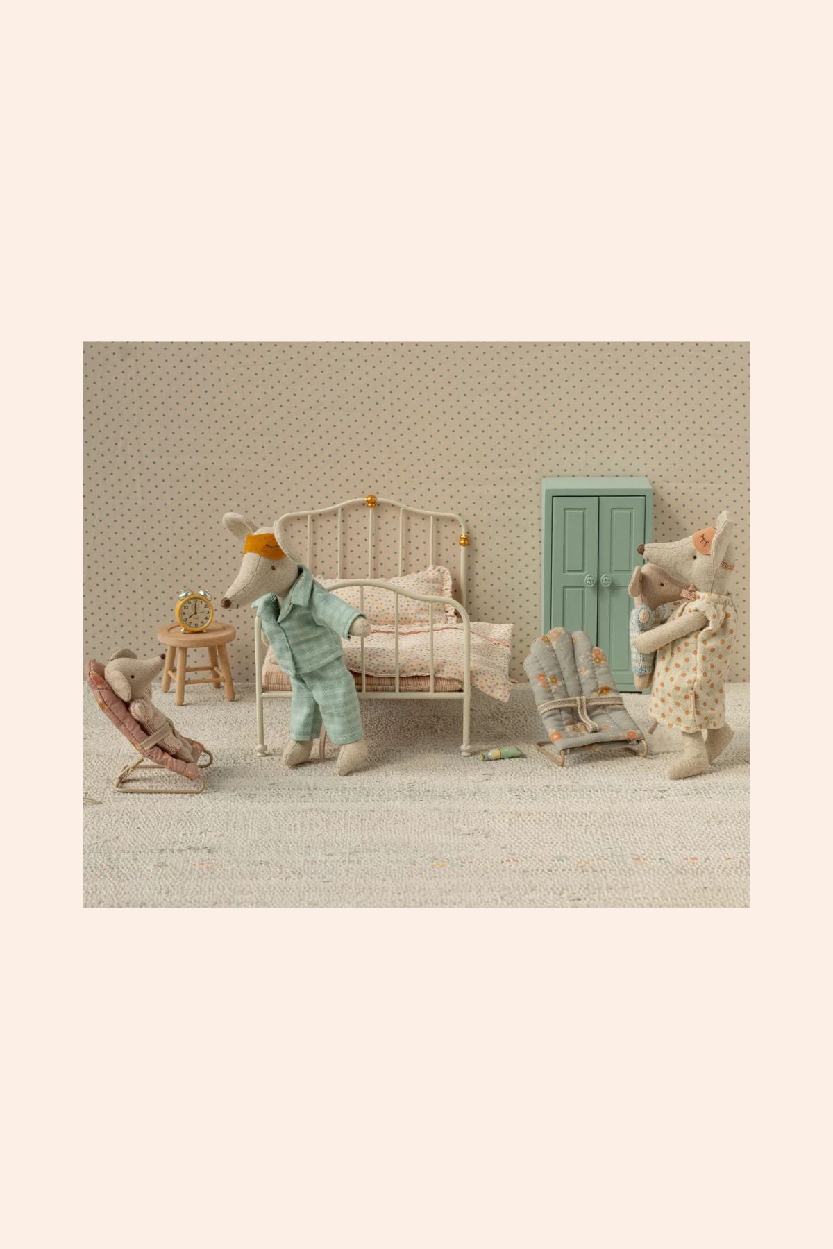 Miniature scene with toy figures in a bedroom setting on a textured beige background