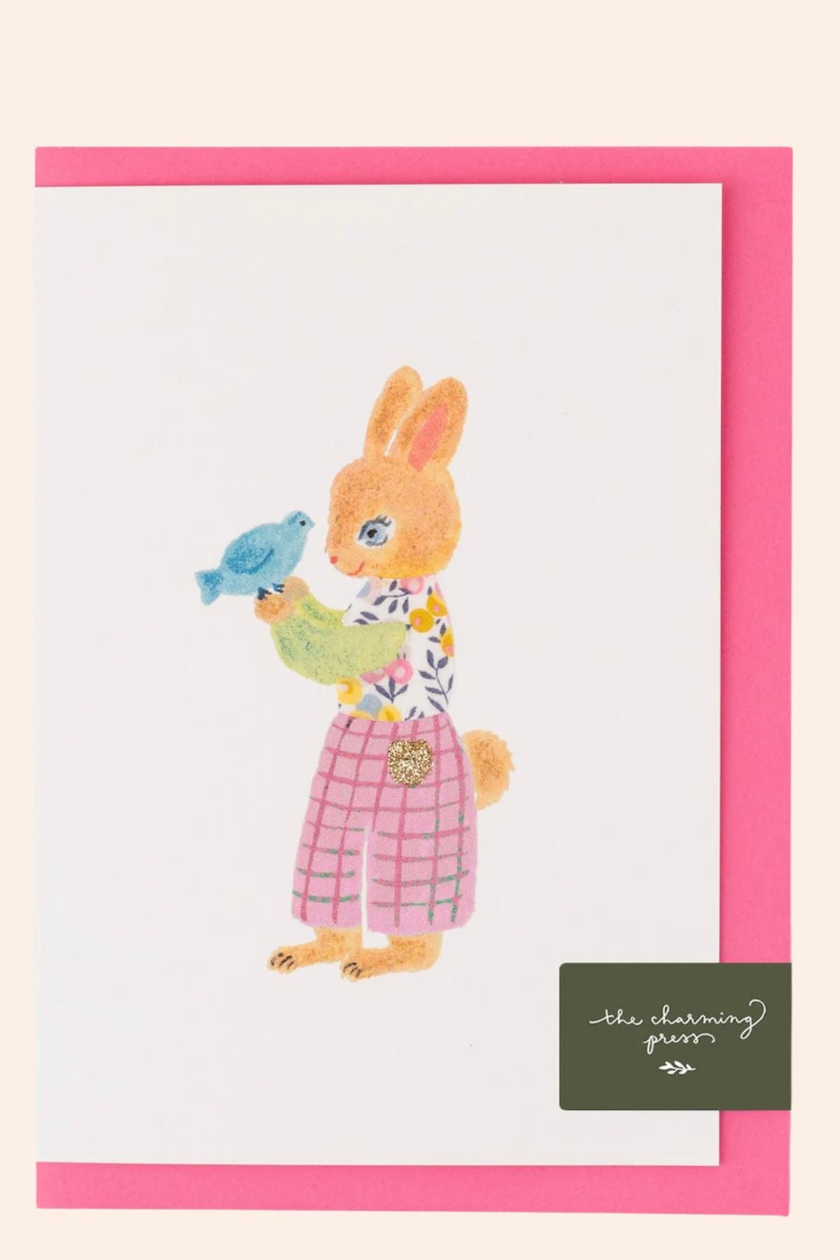 Card with a rabbit holding a bird and a pink border, featuring the brand 'The Charming Press'.